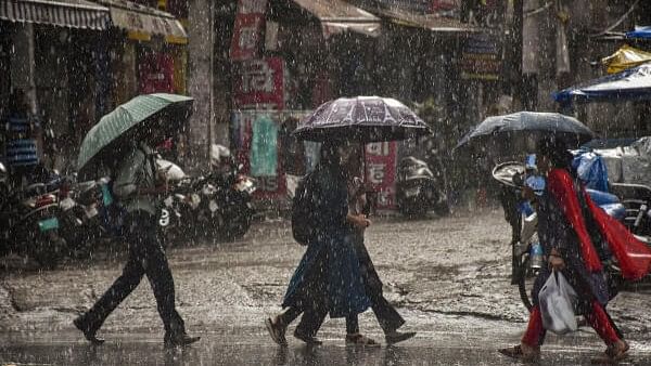 <div class="paragraphs"><p>People holding umbrellas cross a road amid monsoon rains, in Ranchi</p></div>