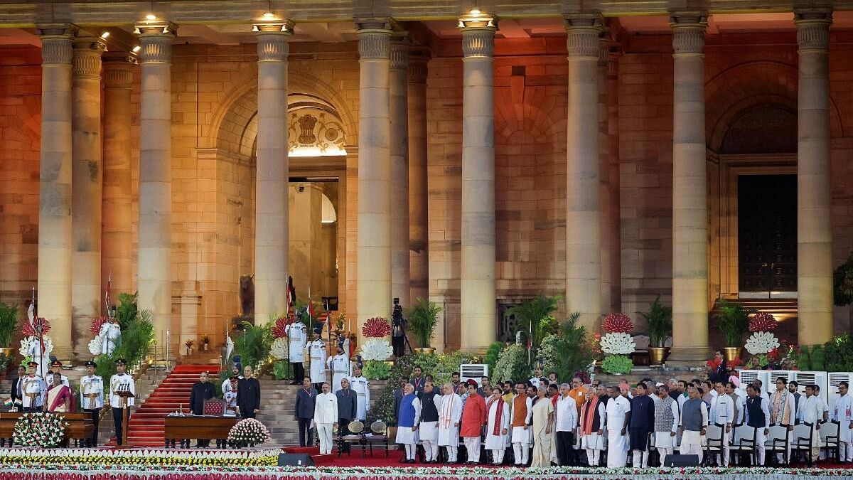<div class="paragraphs"><p>Droupadi Murmu, Prime Minister Narendra Modi and to be sworn-in ministers stand for the national anthem, during the swearing-in ceremony at the presidential palace in New Delhi.&nbsp;</p></div>