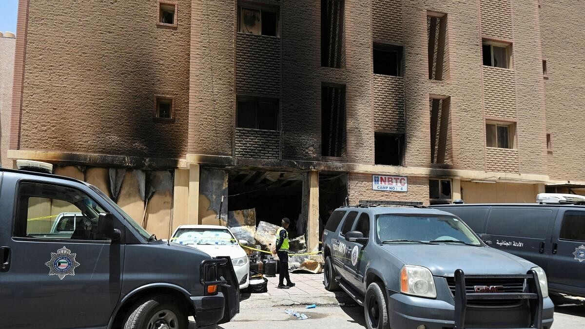 <div class="paragraphs"><p>A Kuwaiti police officer is seen in front of a burnt building following a deadly fire, in Mangaf, southern Kuwait</p></div>