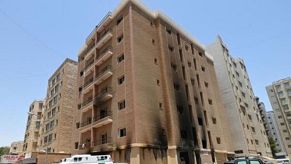 <div class="paragraphs"><p>Vehicles are parked next to a building damaged following a deadly fire, in Mangaf, southern Kuwait</p></div>