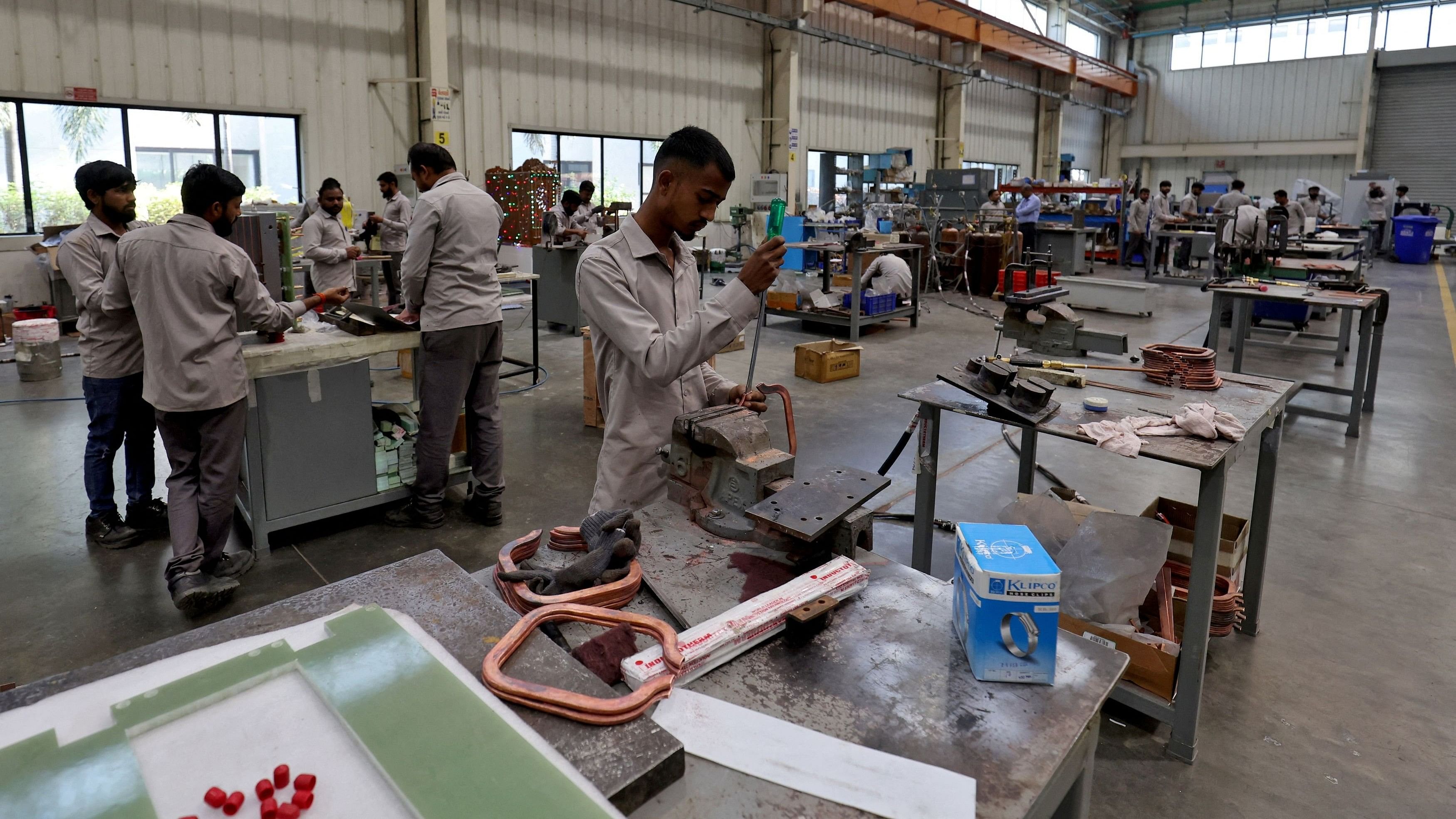 <div class="paragraphs"><p> Employees assemble an electric transformer inside a manufacturing unit of Inductotherm (India) Private Limited at Sanand GIDC (Gujarat Industrial Development Corporation), on the outskirts of Ahmedabad, India, March 28, 2024. </p></div>