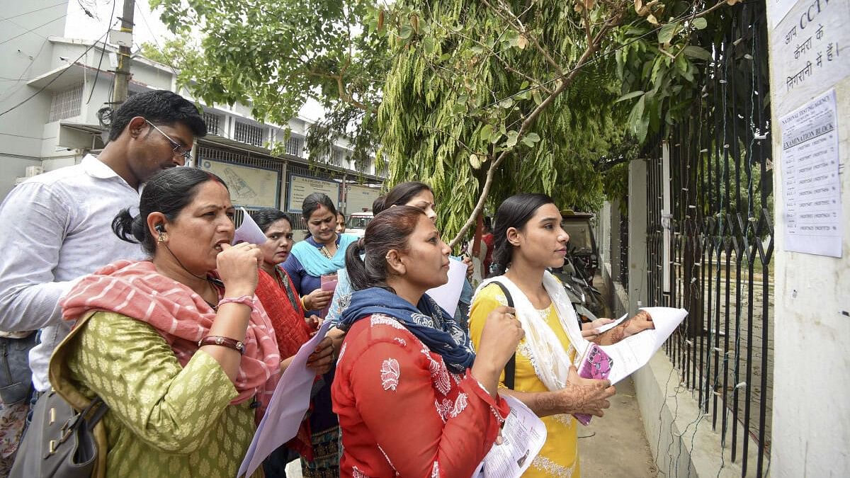 <div class="paragraphs"><p>Aspirants search their roll numbers for seats before entering an examination center to appear in the UGC-NET exam. (Representative file image)</p></div>