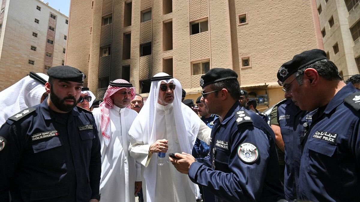 <div class="paragraphs"><p>Deputy Prime Minister and Minister of Defense and acting Interior Minister, Fahad Yusuf Al-Sabah speaks with Kuwaiti police officers in front of a burnt building following a deadly fire, in Mangaf, southern Kuwait, June 12, 2024.</p></div>