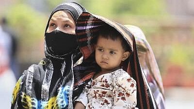 <div class="paragraphs"><p>A woman covers her child in protection from the scorching sun on a hot summer day, in Jaipur.</p></div>