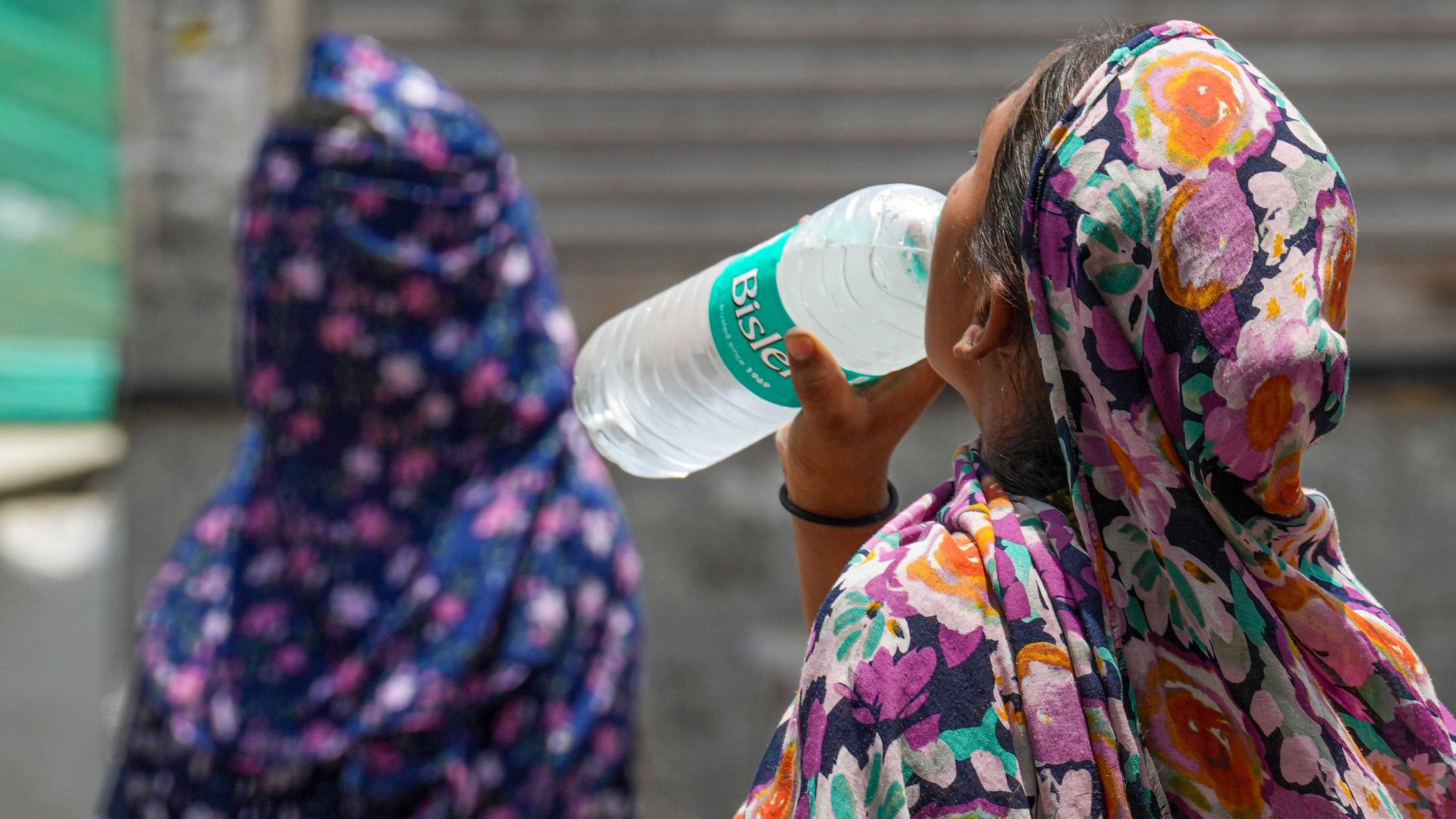 <div class="paragraphs"><p>A woman drinks water to get relief from the scorching heat.</p></div>