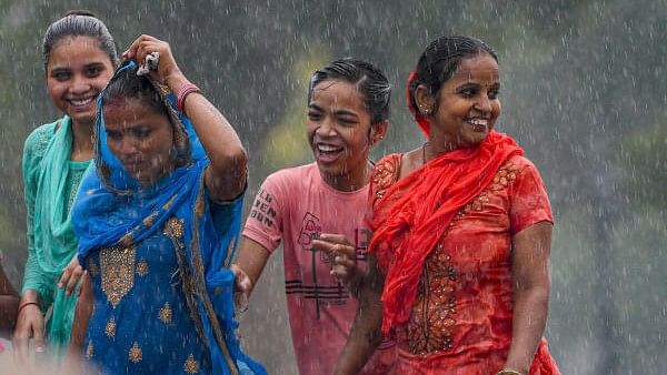 <div class="paragraphs"><p>A group of visitors on the Kartavya Path amid rains, in New Delhi.&nbsp;</p></div>