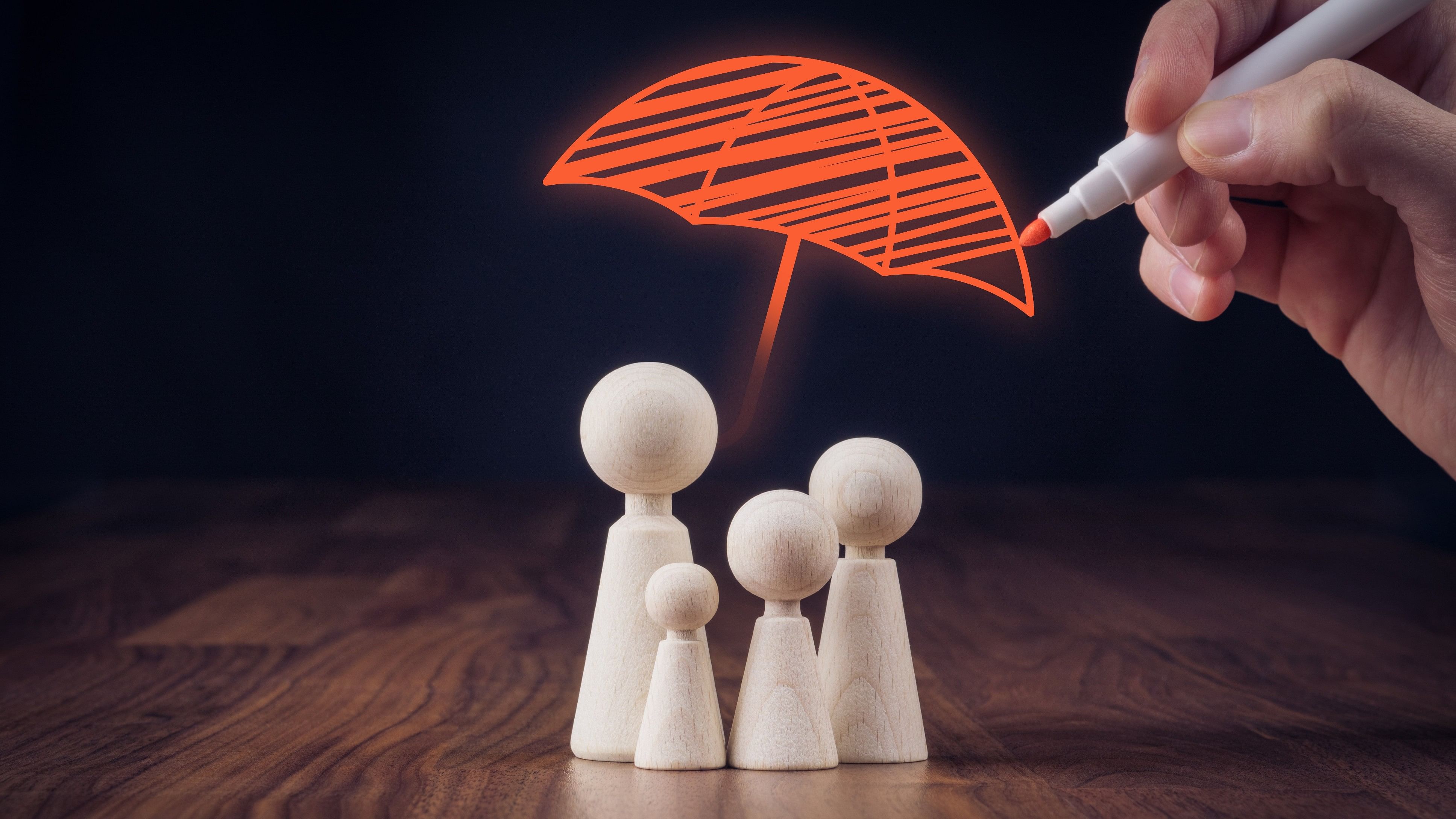 <div class="paragraphs"><p>Family life and property insurance concept. Wooden figurines representing family and hand drawing umbrella, symbol of insurance.</p></div>