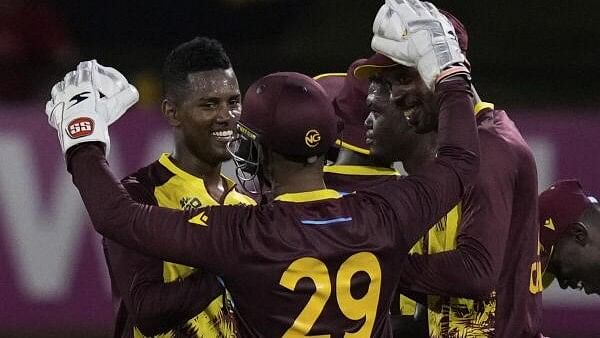 <div class="paragraphs"><p>West Indies' Akeal Hosein, left, celebrates with teammates after their 134-run victory over Uganda during an ICC Men's T20 World Cup cricket match at Guyana National Stadium in Providence, Guyana.</p></div>