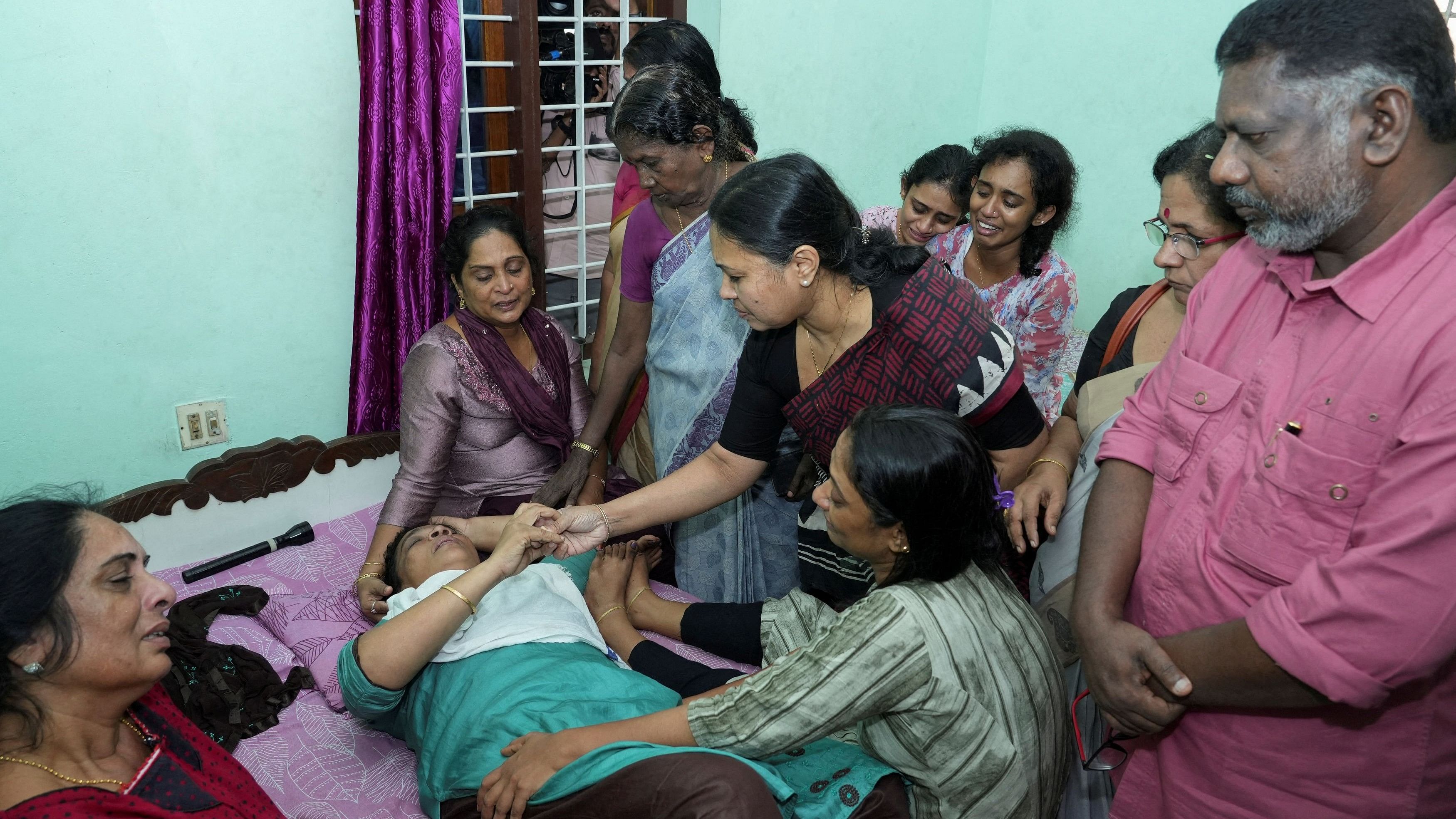 <div class="paragraphs"><p>Veena George, who is Kerala's Minister for Health and Woman and Child Development, consoles the mother of Akash Sasidharan Nair, one of the victims of a fire that broke out in a building housing foreign workers in Kuwait, at Pathanamthitta district in the southern Indian state of Kerala, June 13.</p></div>