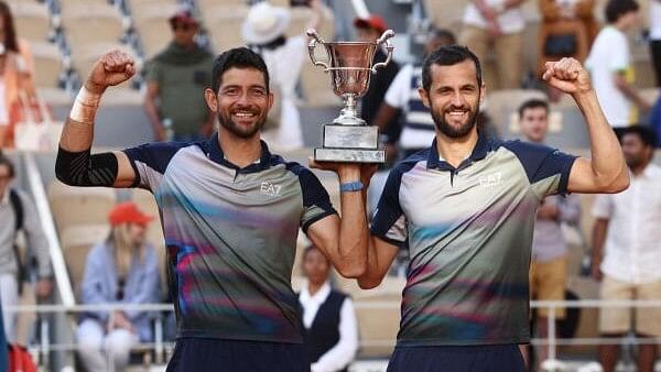 <div class="paragraphs"><p> El Salvador's Marcelo Arevalo and Croatia's Mate Pavic pose for a picture with their trophy after winning the doubles match final against Italy's Simone Bolelli and Andrea Vavassori.</p></div>