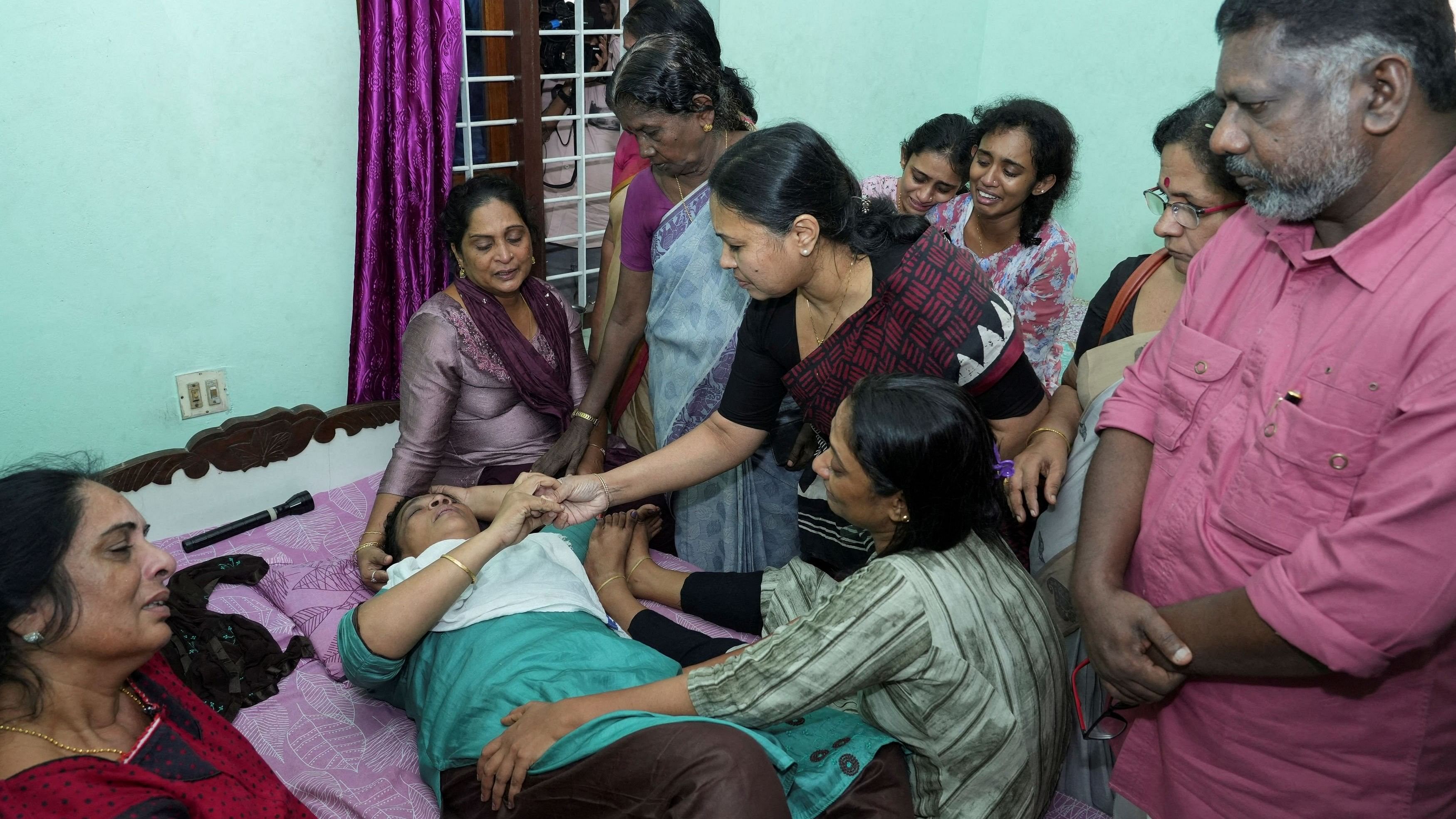 <div class="paragraphs"><p>Veena George, Kerala Minister for Health and Woman and Child Development, consoles the mother of Akash Sasidharan Nair, one of the victims of a fire that broke out in a building housing foreign workers in Kuwait, at Pathanamthitta district in the southern Indian state of Kerala, June 13, 2024. </p></div>