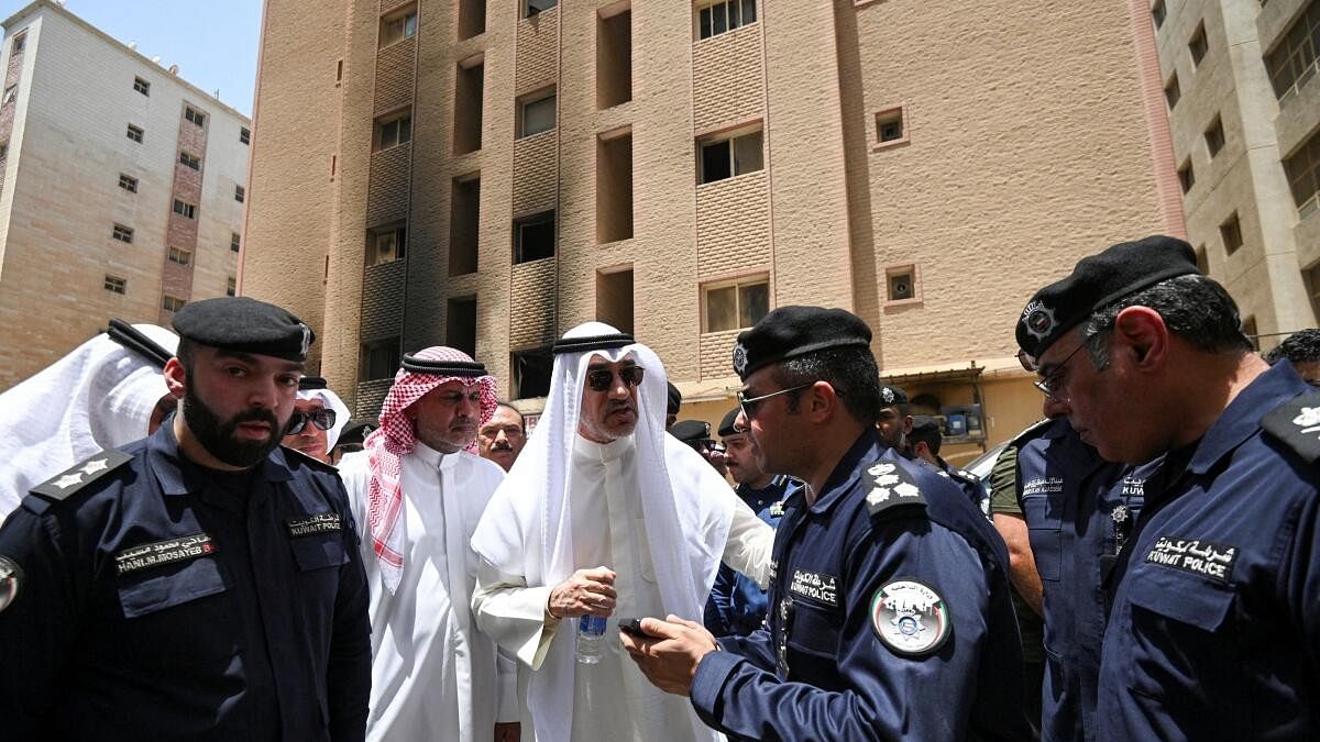 <div class="paragraphs"><p>Kuwait's Deputy Prime Minister and Minister of Defense and acting Interior Minister, Fahad Yusuf Al-Sabah speaks with police officers in front of a burnt building, following a deadly fire, in Mangaf, southern Kuwait, June 12, 2024.</p></div>