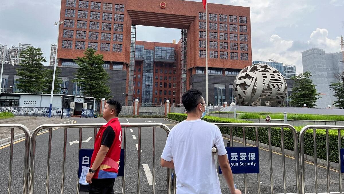 <div class="paragraphs"><p>People stand outside Guangzhou Intermediate People's Court, where activists Huang Xueqin and Wang Jianbing were sentenced.</p></div>