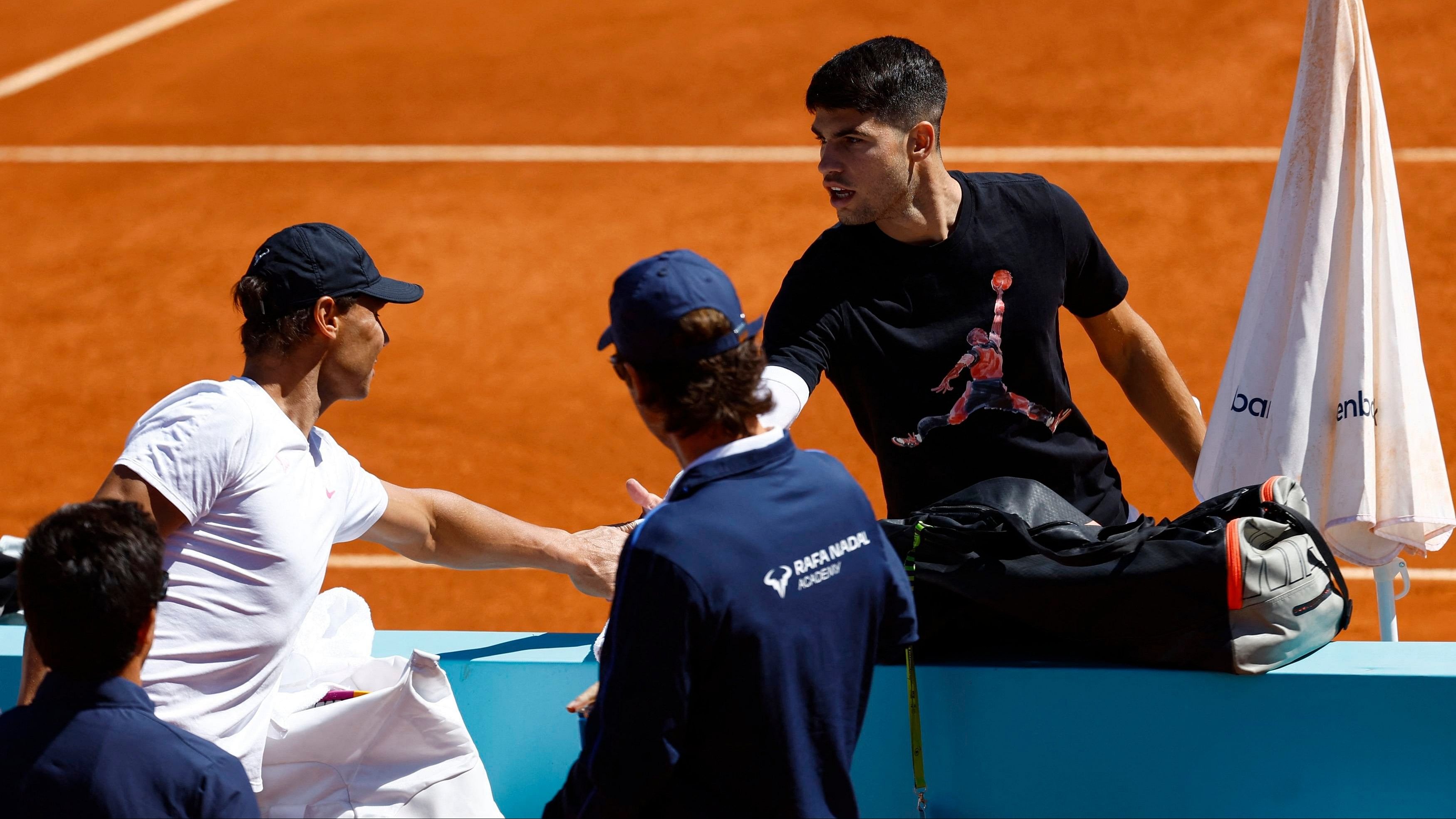 <div class="paragraphs"><p>Carlos Alcaraz shakes hands with compatriot Rafael Nadal during a&nbsp; practice session.</p></div>