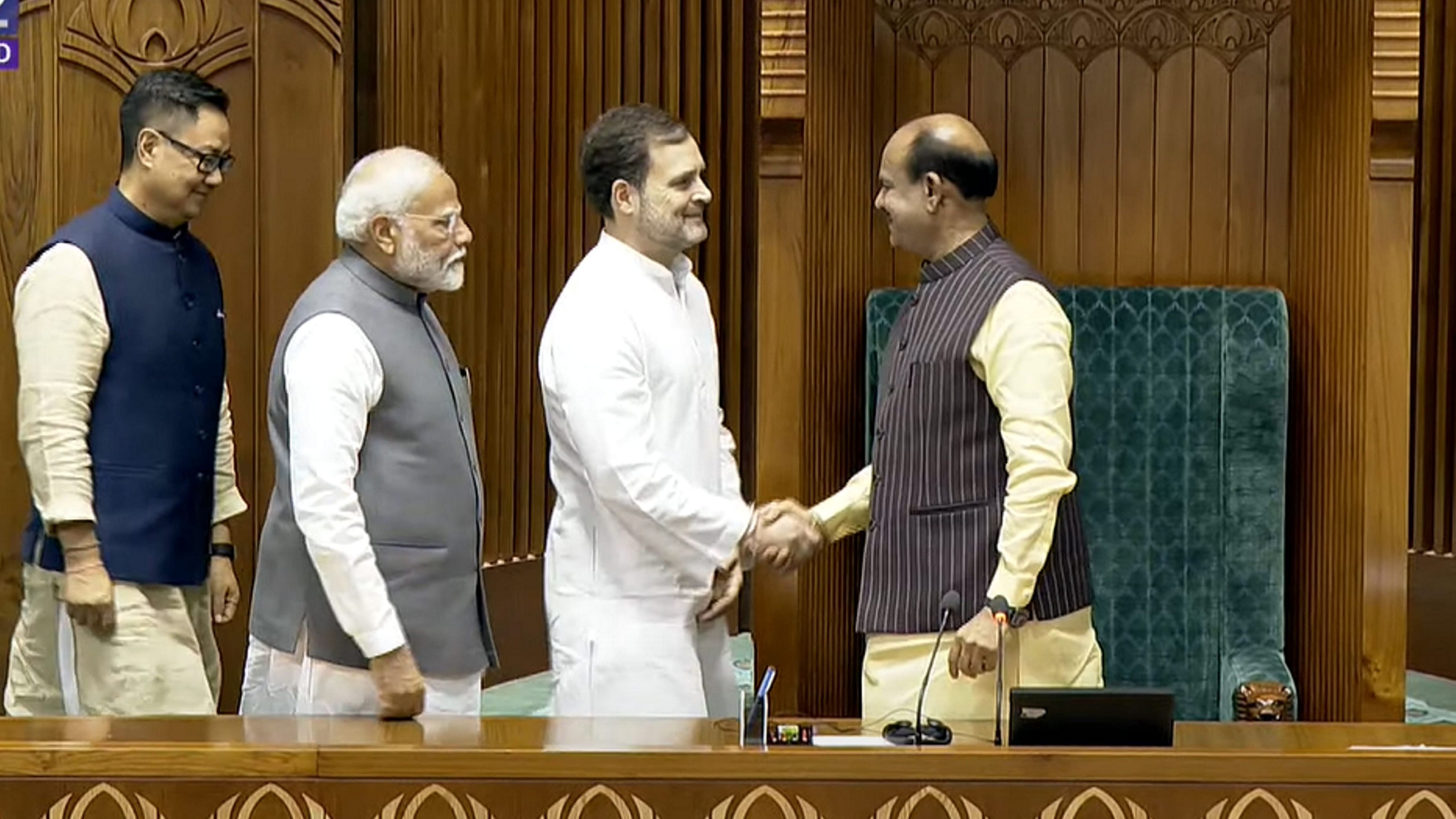 <div class="paragraphs"><p>Prime Minister Narendra Modi, Leader of the Opposition Rahul Gandhi and Union Minister for Parliamentary Affairs Kiren Rijiju greet Om Birla after the latter was elected as the Speaker of the House during the first session of the 18th Lok Sabha, in New Delhi, Wednesday, June 26, 2024. </p></div>