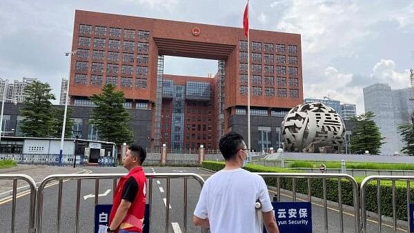 <div class="paragraphs"><p>People stand outside Guangzhou Intermediate People's Court, where #MeToo activist Huang Xueqin and labour activist Wang Jianbing were sentenced</p></div>