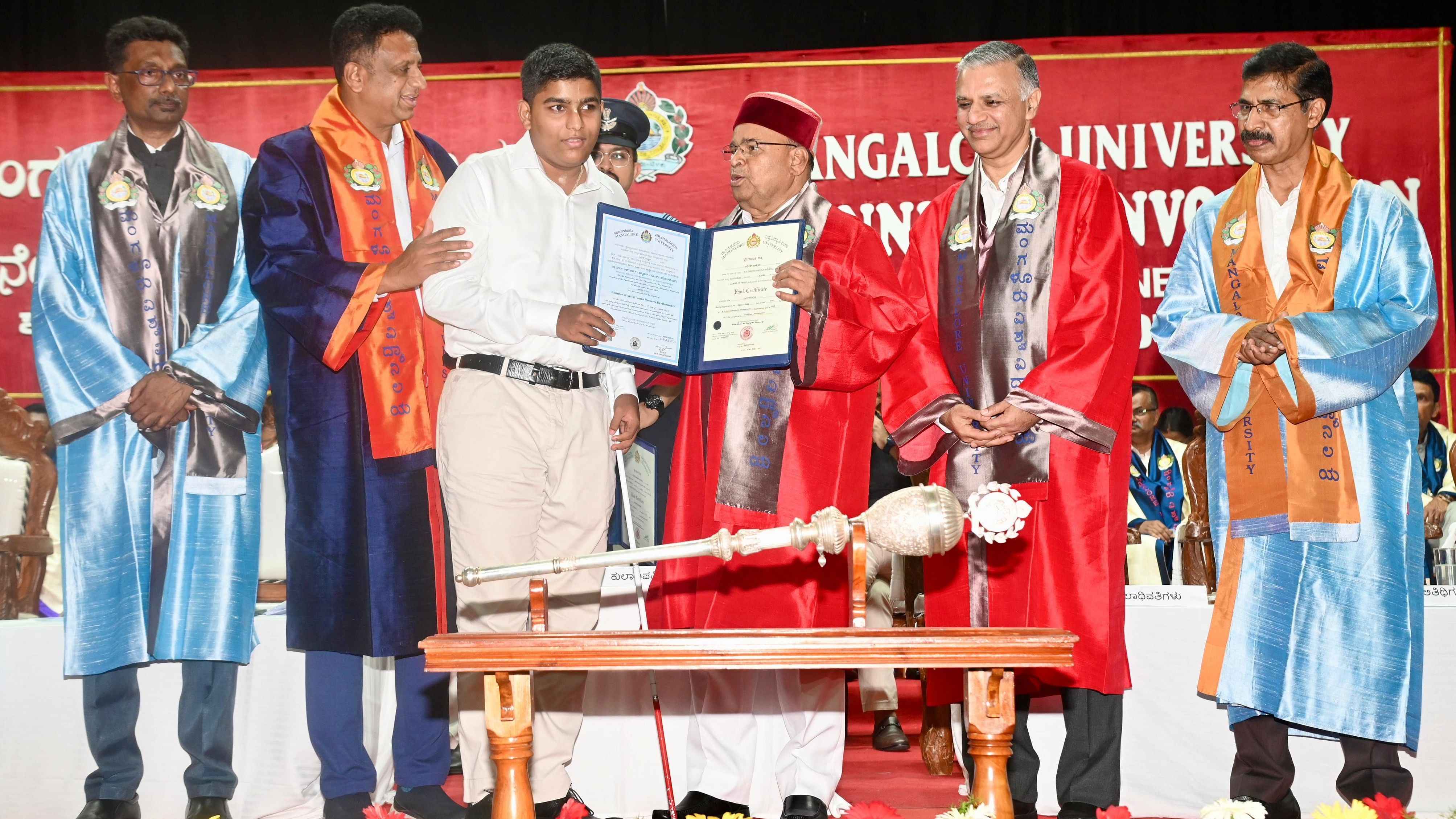 <div class="paragraphs"><p>Adhish Uchil who secured first rank in BA (HRD) receives his rank certificate from Governor Thawar Chand Gehlot during the 42nd annual convocation of Mangalore University, at Mangalagangothri on Saturday.</p></div>