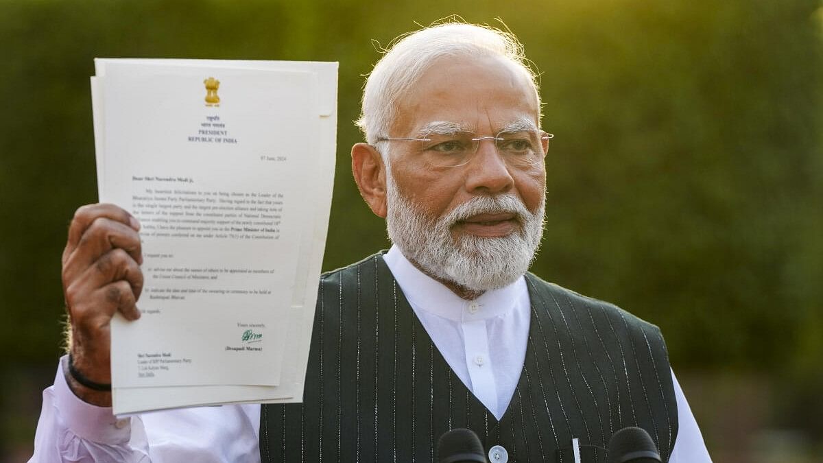 <div class="paragraphs"><p>Prime Minister Narendra Modi shows to the media the letter of his appointment as Prime Minister by President Droupadi Murmu</p></div>