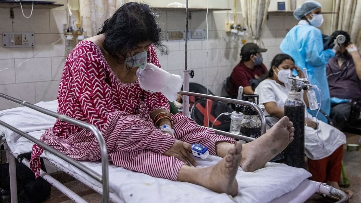 <div class="paragraphs"><p>Pratibha Rohilla who is suffering from the coronavirus disease (COVID-19), sits on a bed inside the emergency room of Holy Family Hospital in New Delhi.</p></div>