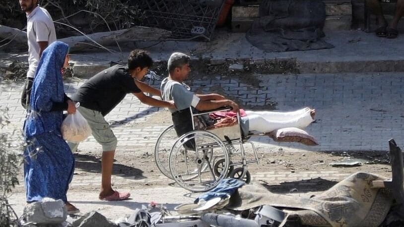 <div class="paragraphs"><p>A young man pushes a wheelchair with an injured person, aftermath of Israeli strikes at the area, where Israeli hostages were rescued on Saturday, as Palestinian death toll rises to 274, amid the Israel-Hamas conflict, in Nuseirat refugee camp in the central Gaza Strip.</p></div>