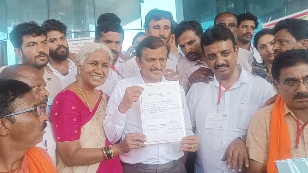 <div class="paragraphs"><p>BJP candidate from Bangalore Rural Dr C N Manjunath shows the election certificate along with his wife Anasuya. Party workers look on. </p></div>