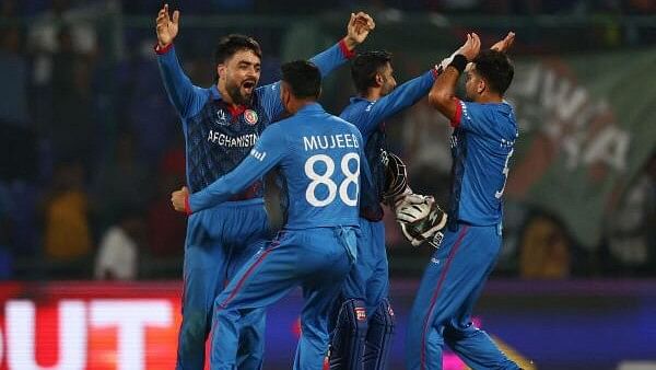 <div class="paragraphs"><p>Afghanistan's Rashid Khan celebrates with Mujeeb Ur Rahman and teammates after taking the wicket of England's Mark Wood.</p></div>