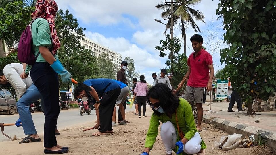 <div class="paragraphs"><p>Residents clean a dust-filled stretch of Balagere Road on Sunday. </p></div>
