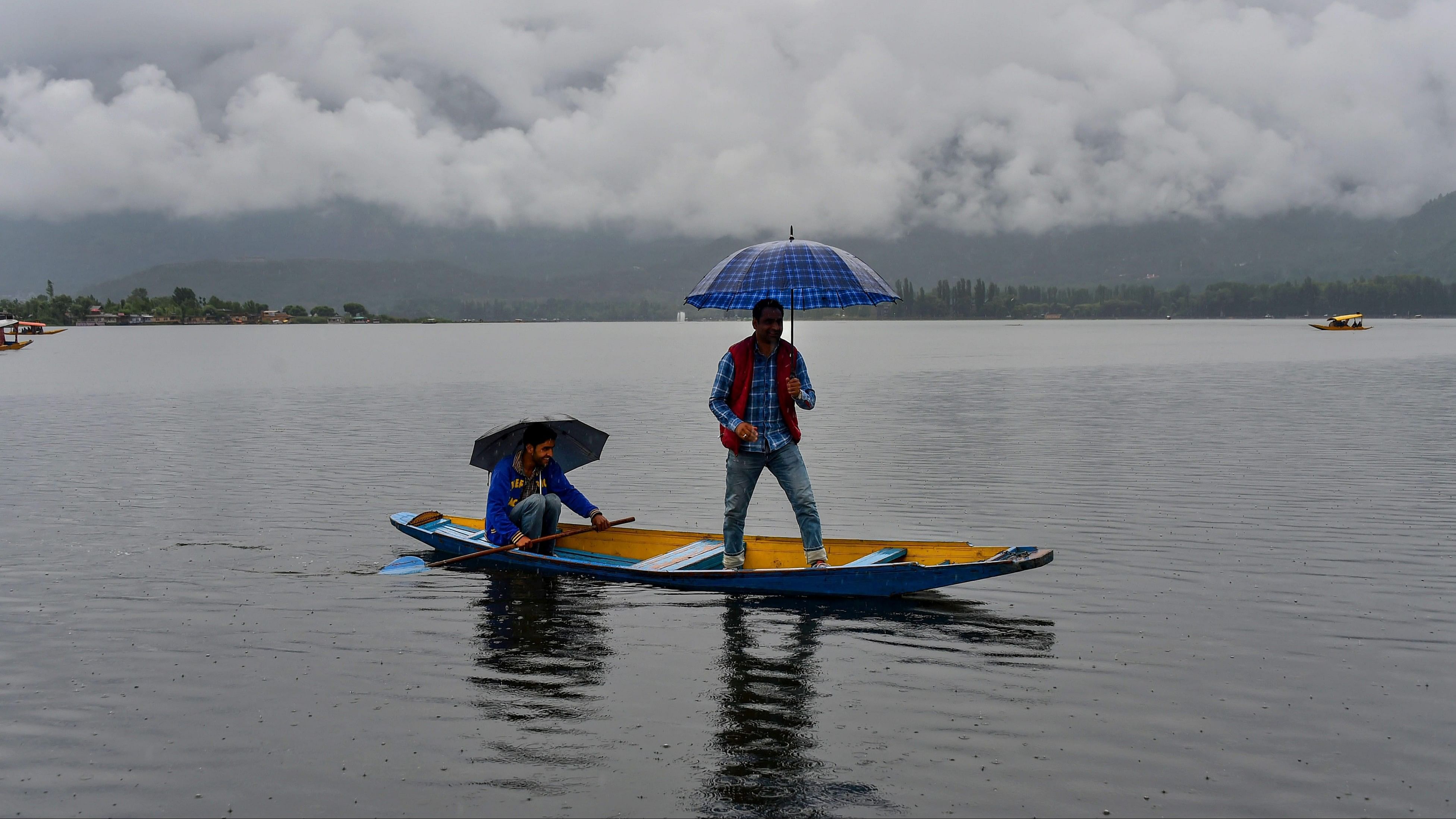 <div class="paragraphs"><p>People seen on the Dal Lake with an umbrella amid rains.</p></div>