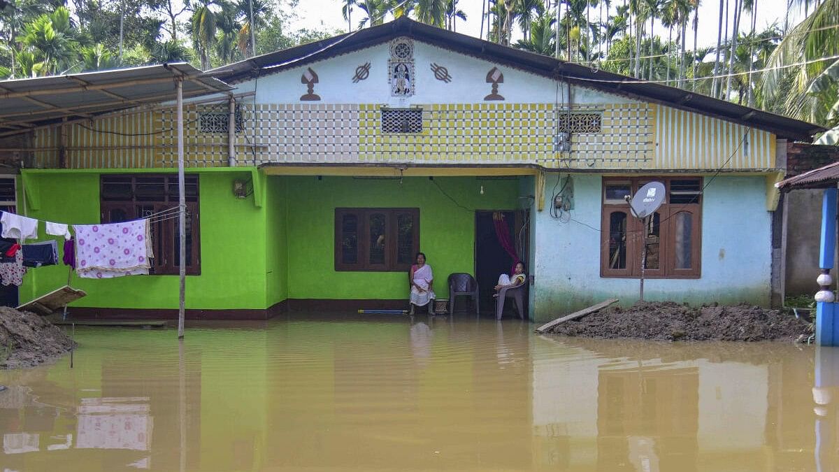 <div class="paragraphs"><p>Women sit outside their partially submerged house following incessant rains, at Kampur, in Nagaon district, Thursday, June 20, 2024</p></div>