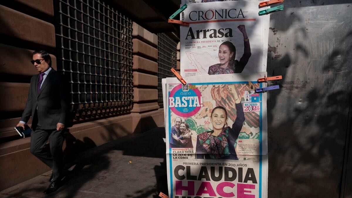 <div class="paragraphs"><p>A man walks past newspapers displaying the victory of the presidential candidate of the ruling Morena party Claudia Sheinbaum, a day after the general election.</p></div>