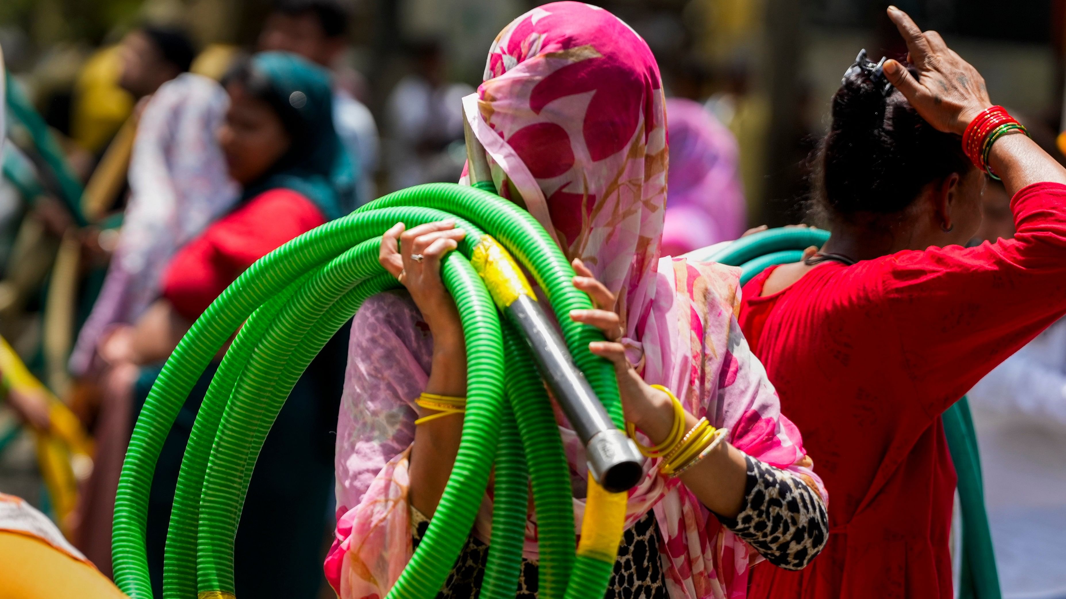 <div class="paragraphs"><p>New Delhi:A woman carries a water pipe amid the ongoing water crisis, at Chanakyapuri, in New Delhi,</p></div>