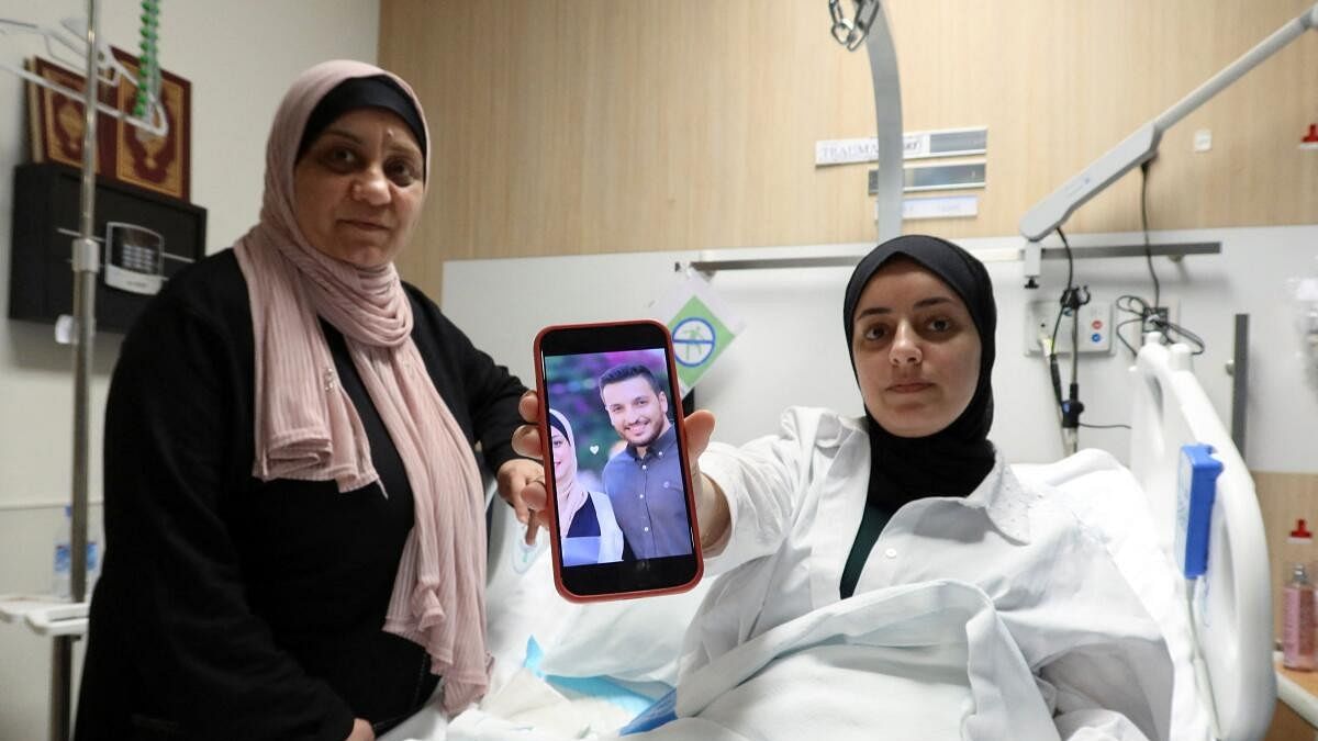 <div class="paragraphs"><p>Shahed Al-Kotati, a wounded from Gaza, shows the picture of her killed husband as she sits in bed at a hospital in Doha.</p></div>