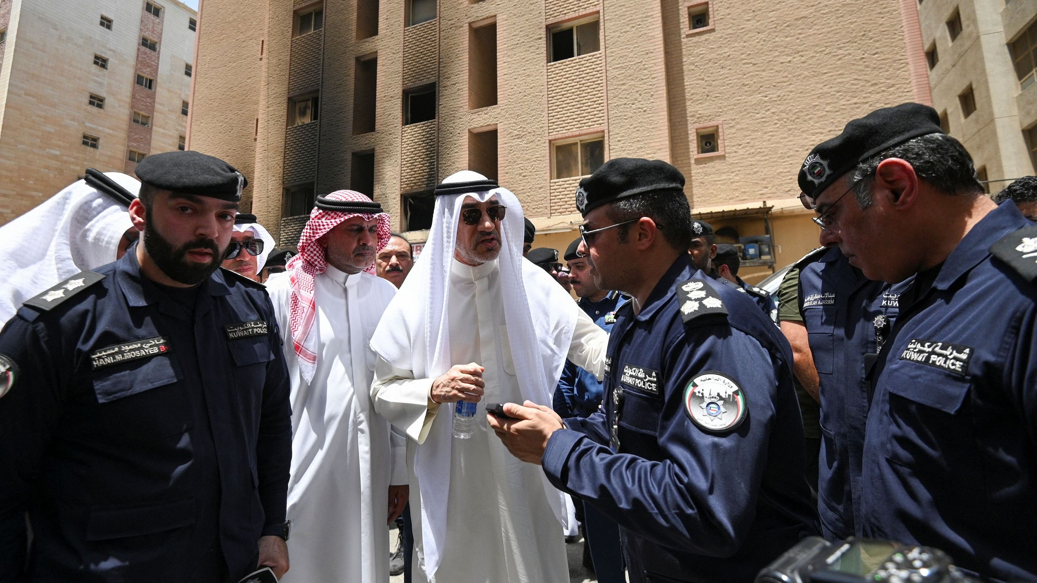 <div class="paragraphs"><p>Deputy Prime Minister and Minister of Defense and acting Interior Minister, Fahad Yusuf Al-Sabah speaks with Kuwaiti police officers in front of a burnt building following a deadly fire, in Mangaf, southern Kuwait, June 12, 2024. </p></div>