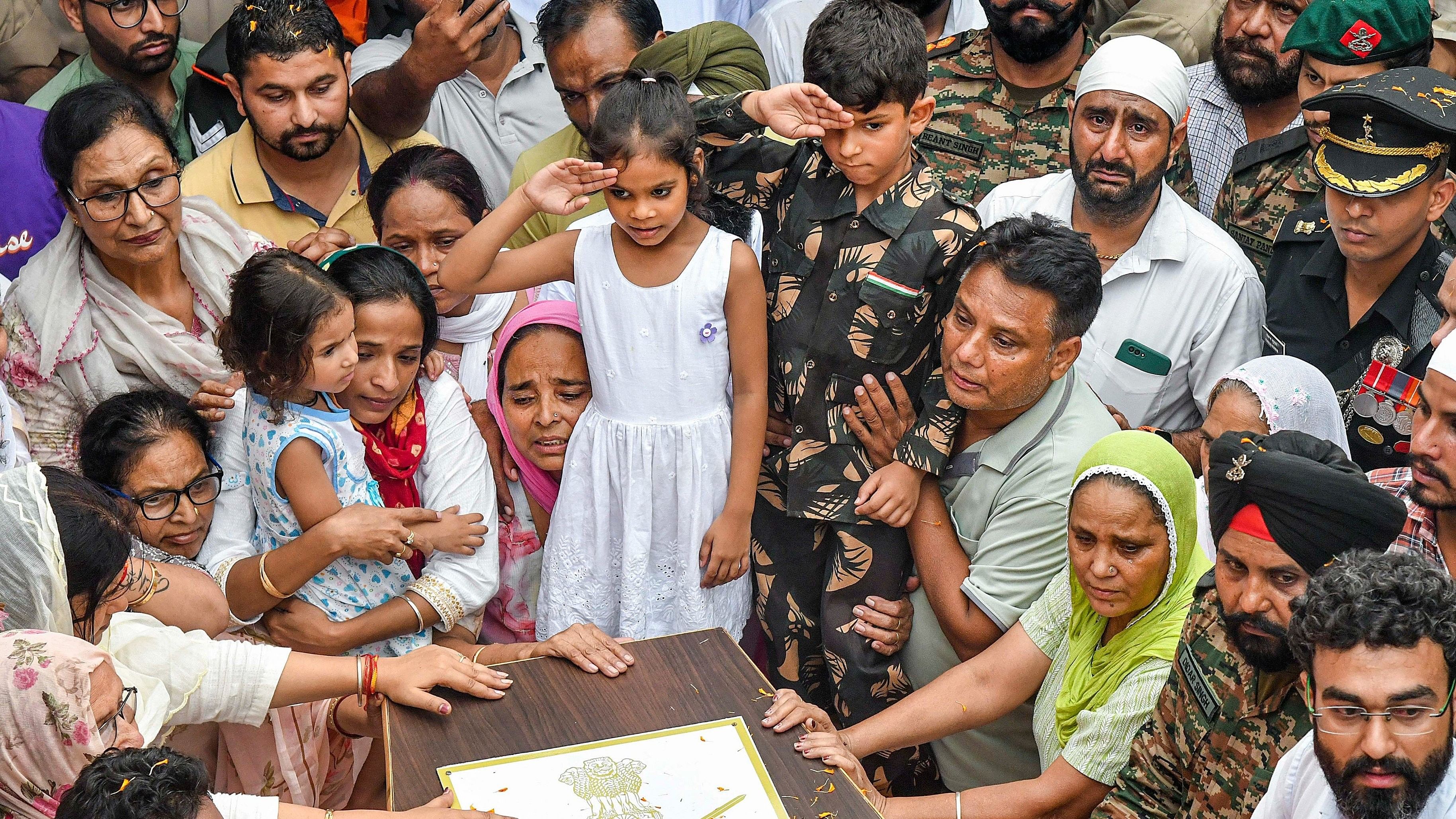 <div class="paragraphs"><p>Son of Colonel Manpreet Singh salutes as family members and relatives mourn near his mortal remains before his last rites.</p></div>