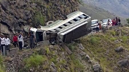 <div class="paragraphs"><p>Locals gather after a Himachal Roadways Transport Corporation (HRTC) bus overturned on the Kuddu-Diltari road, in Shimla district, Friday, June 21, 2024.</p></div>