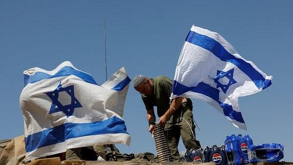 <div class="paragraphs"><p>Israeli soldiers stand on top of a tank.</p></div>