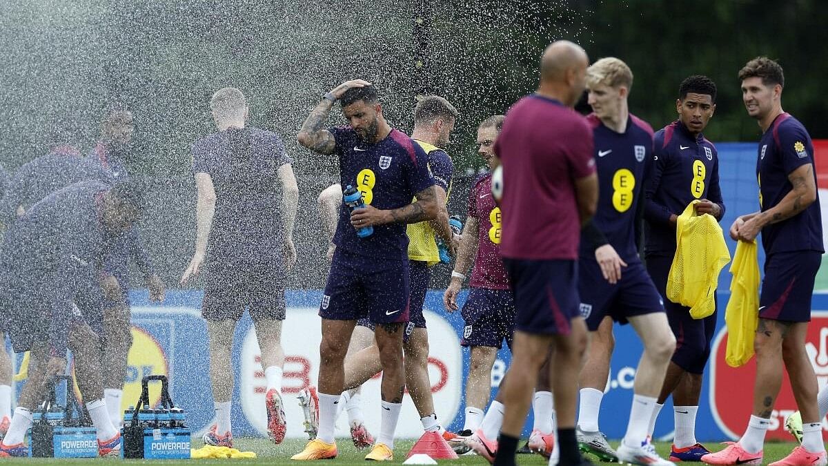 <div class="paragraphs"><p>England's Kyle Walker and Jude Bellingham with teammates as a sprinkler goes off during training.</p></div>
