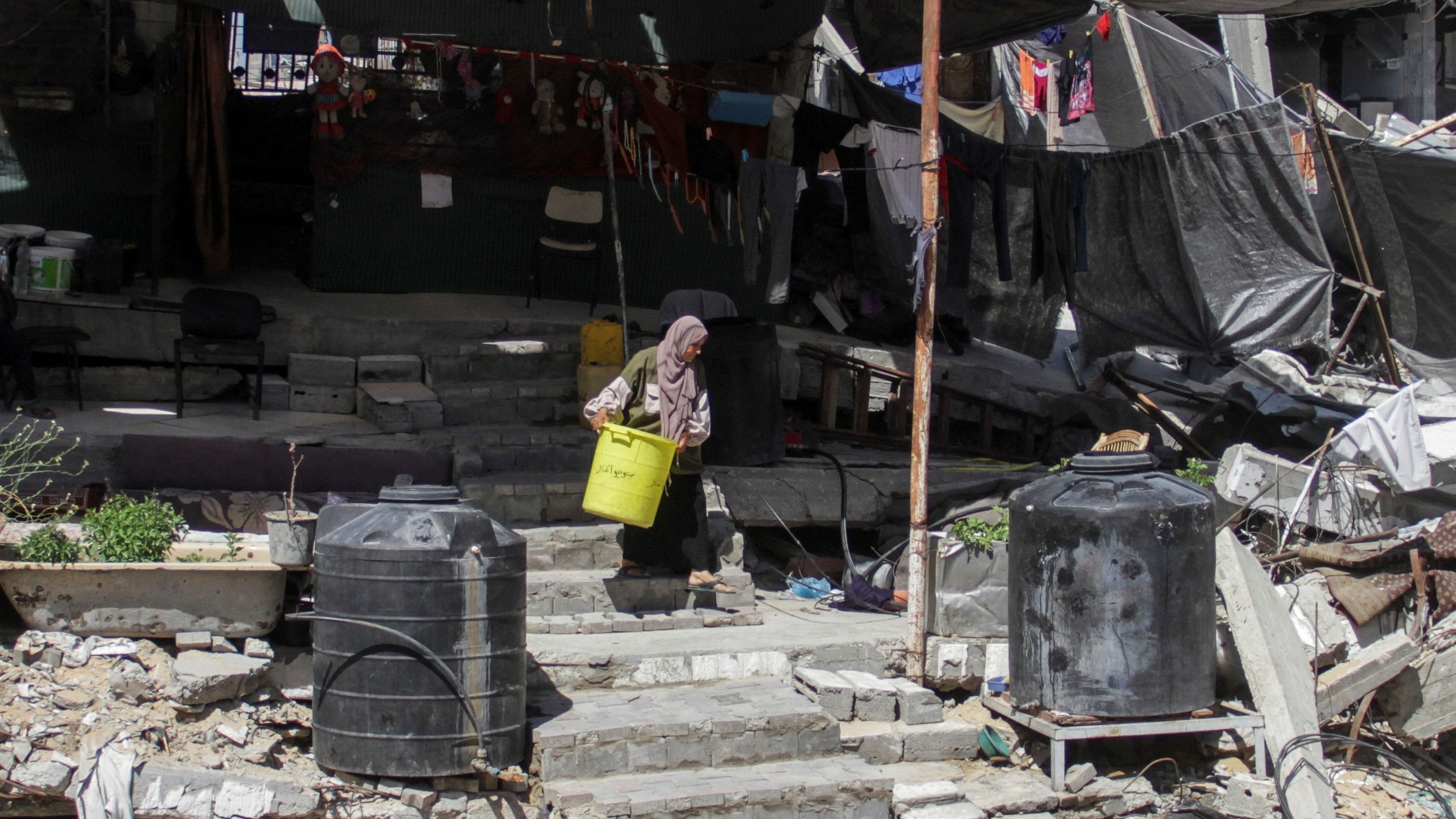 <div class="paragraphs"><p>A Palestinian woman walks among the rubble of a damaged building in the northern Gaza Strip on June 12, 2024. </p></div>