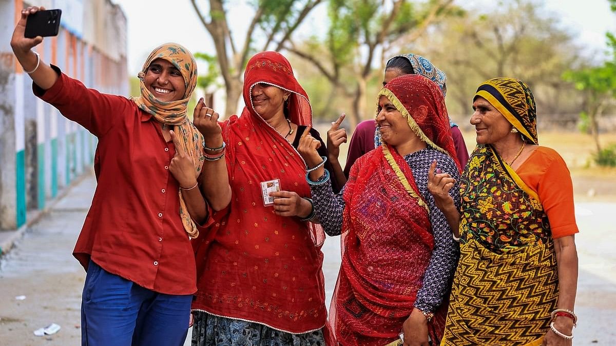 <div class="paragraphs"><p>Women voters take a selfie showing their fingers marked with indelible ink after casting votes.</p></div>