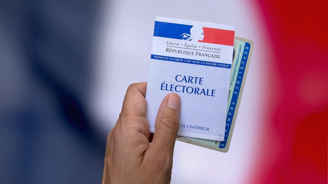 <div class="paragraphs"><p>A representative image of a person&nbsp;holds an electoral card and an identity card to vote in France.&nbsp;</p></div>