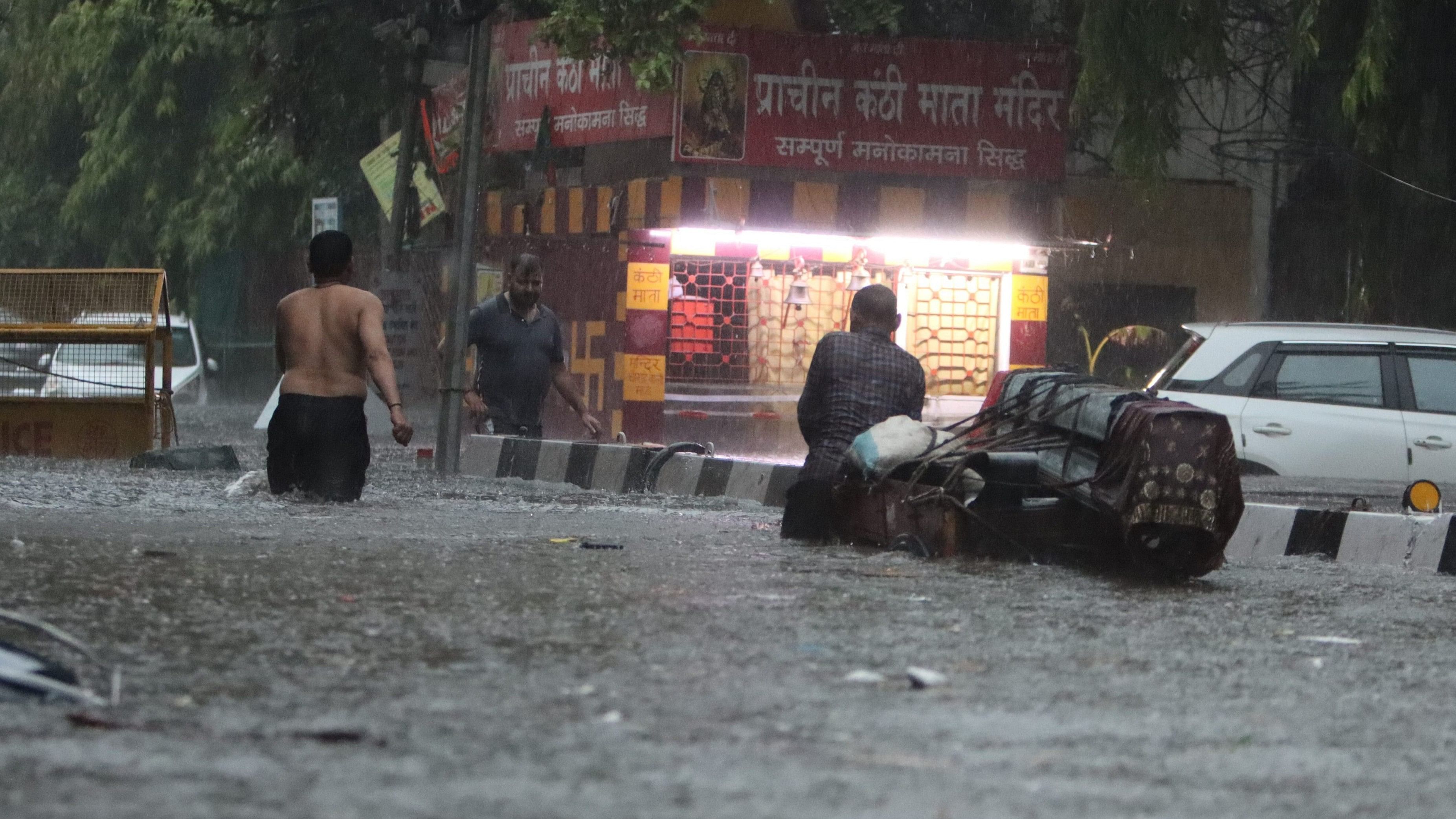<div class="paragraphs"><p>People wade through a waterlogged road amid rains, in New Delhi, Friday morning, June 28, 2024.</p></div>