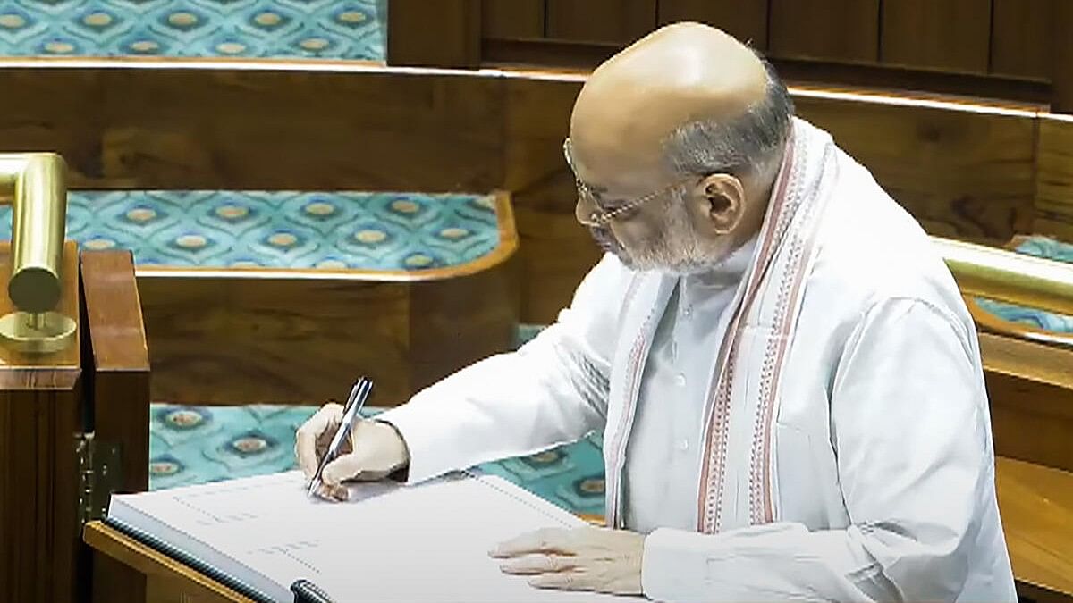 <div class="paragraphs"><p>Union Home Minister Amit Shah signs a register after taking oath as a member of the House during the first day of the first session of the newly-constituted 18th Lok Sabha.</p></div>