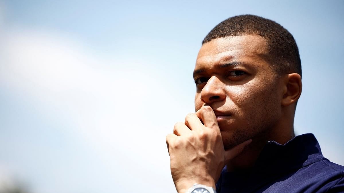 French soccer player Kylian Mbappe listens to French President Emmanuel Macron as he arrives for a lunch at their training camp ahead of the UEFA Euro 2024, in Clairefontaine-en-Yvelines, France, June 3, 2024. REUTERS/Sarah Meyssonnier/Pool