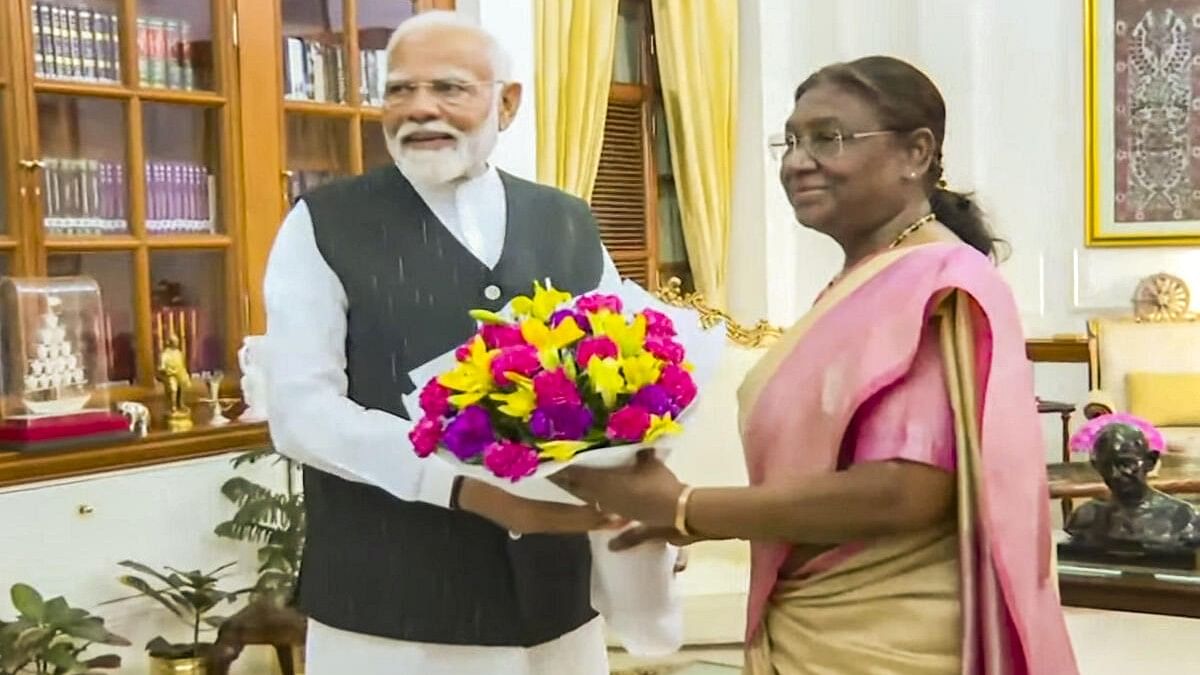 <div class="paragraphs"><p>President Droupadi Murmu greets Prime Minister Narendra Modi at the Rashtrapati Bhavan ahead of government formation, in New Delhi.</p></div>