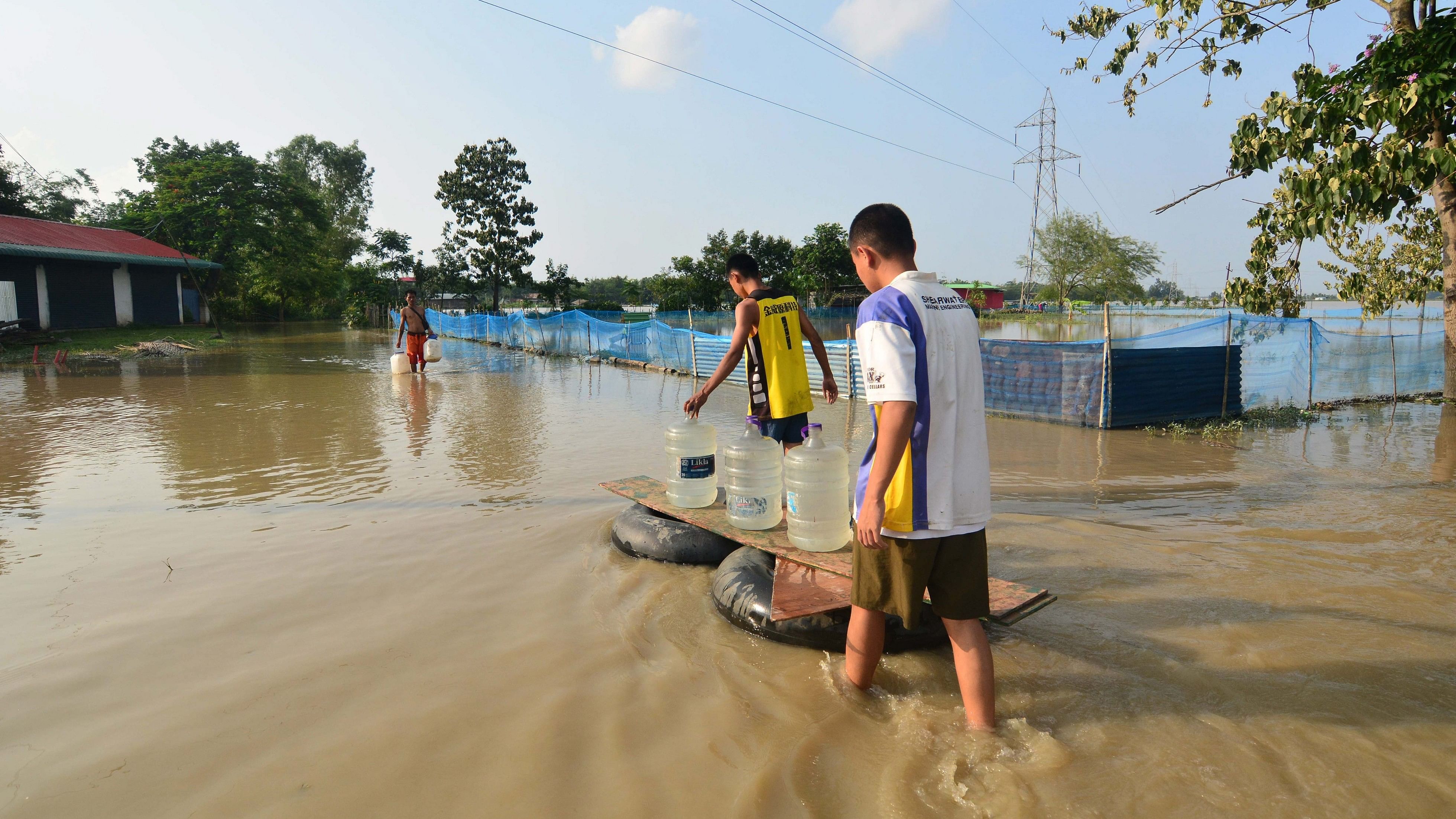 <div class="paragraphs"><p>Residents transport drinking water on a makeshift raft in a flood-affected area on the outskirts of Imphal, Saturday, June 1, 2024.</p></div>