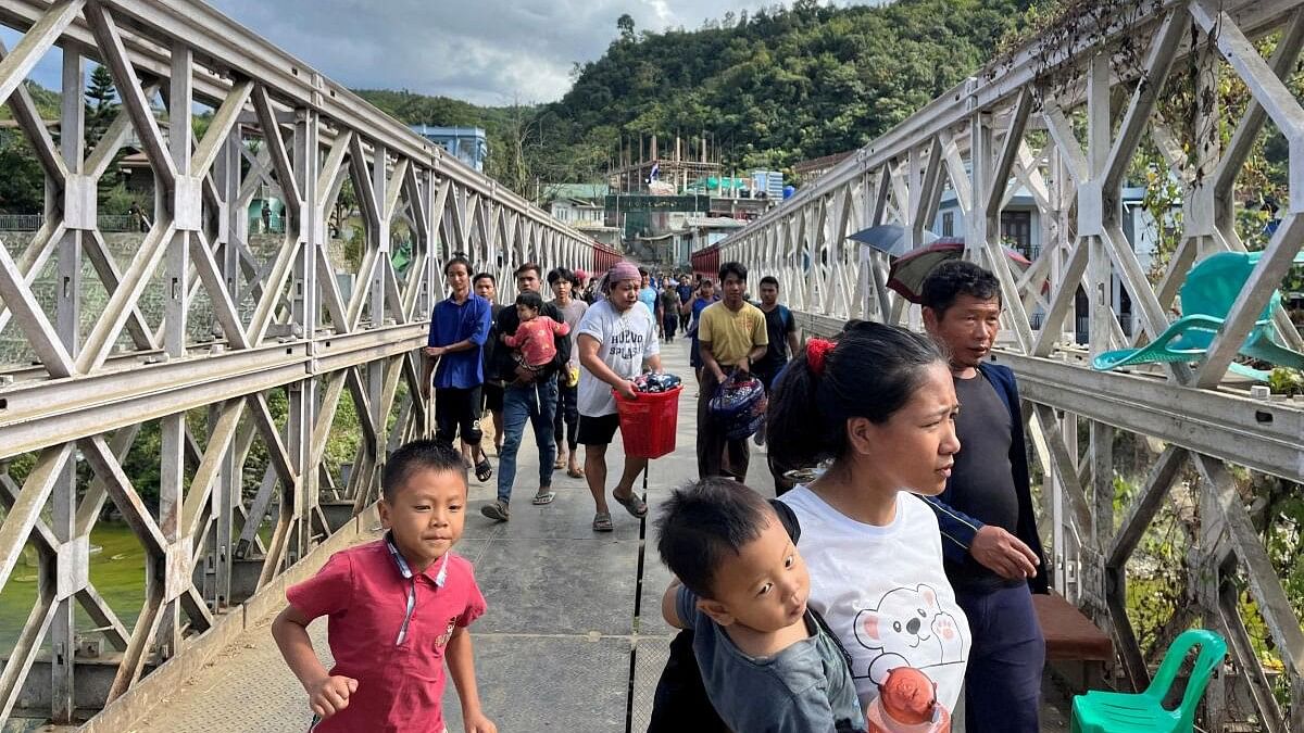 <div class="paragraphs"><p>People who fled Myanmar carry their belongings across a bridge that connects Myanmar and India at the border village of Zokhawthar, Champhai district, in India's northeastern state of Mizoram, India.</p></div>