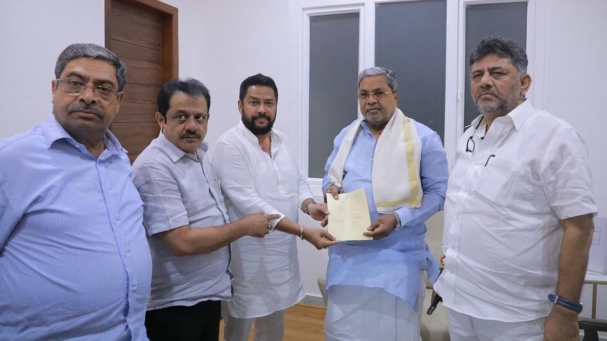 <div class="paragraphs"><p>B Nagendra hands over his resignation to Siddaramaiah as DK Shivakumar looks on.</p></div>