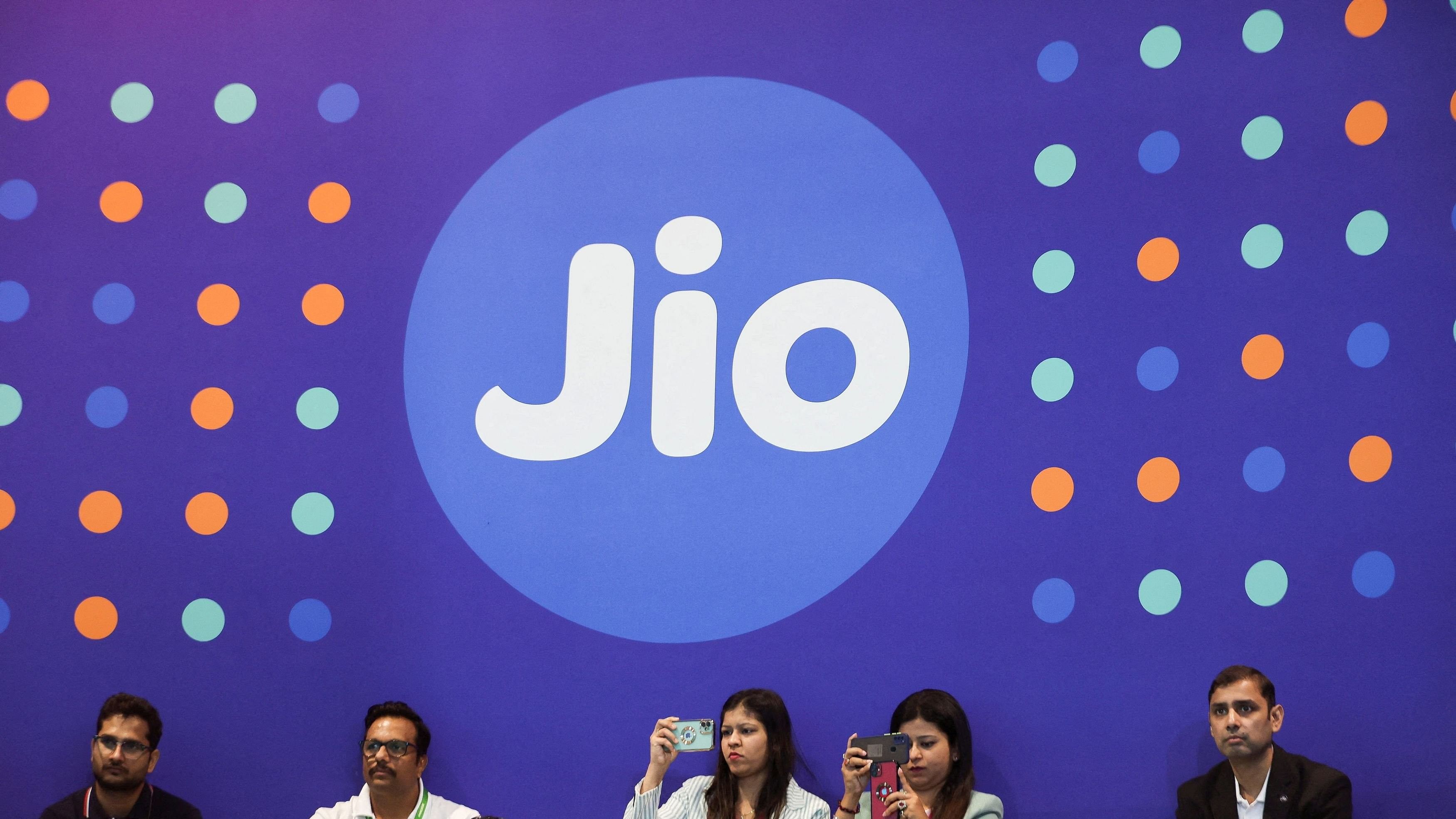 <div class="paragraphs"><p> People take pictures with their mobile phones in front of the logo of Jio.</p></div>