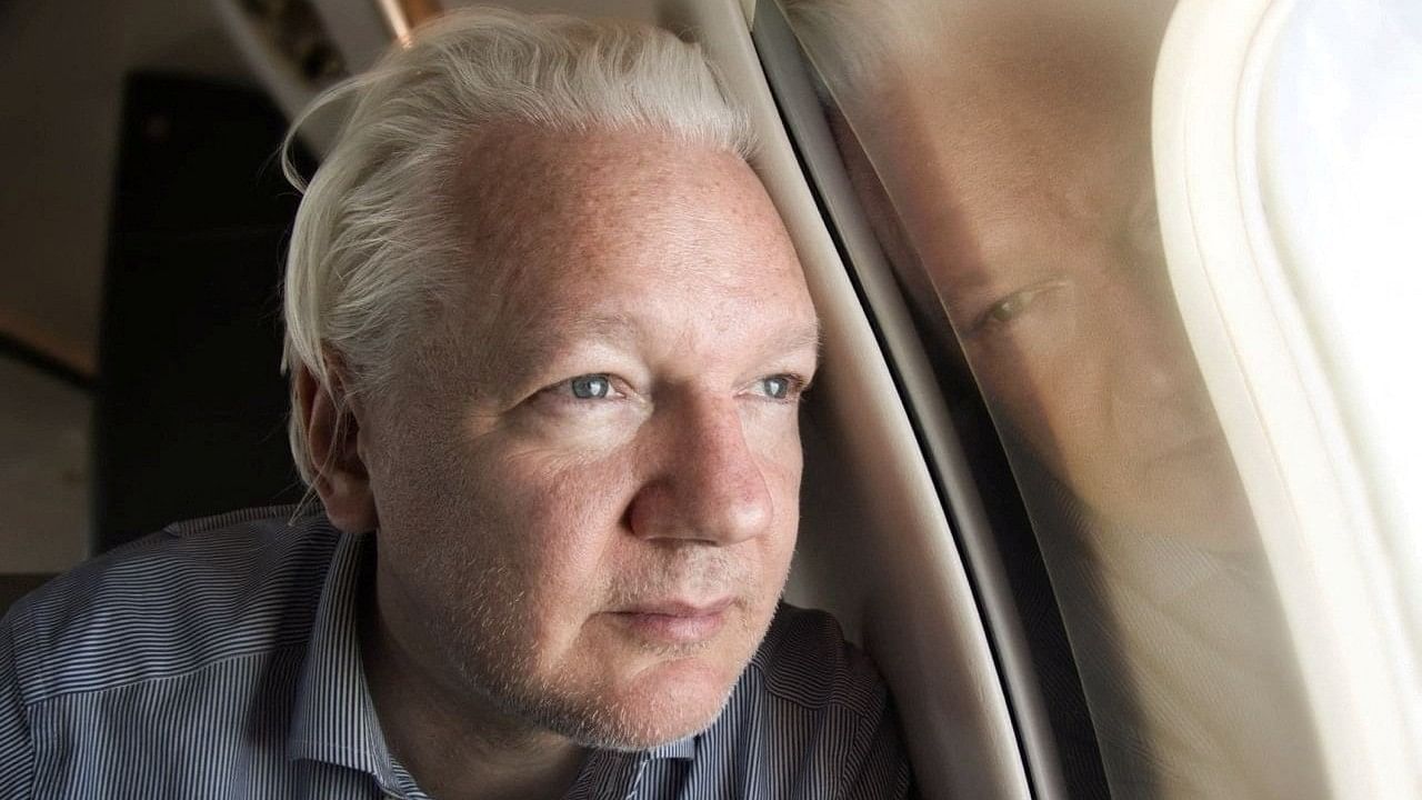 <div class="paragraphs"><p>WikiLeaks founder Julian Assange looks out a plane window.</p></div>