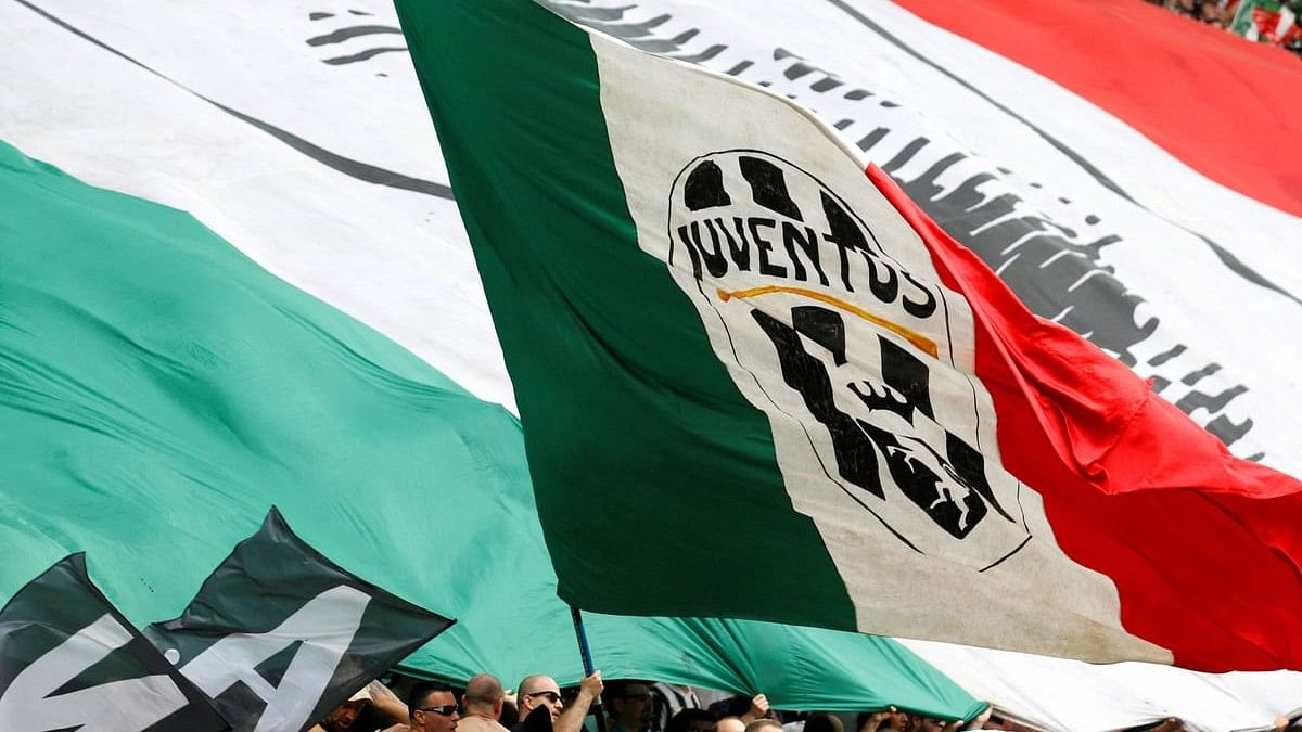 <div class="paragraphs"><p>A Juventus supporter waves a giant Italian flag with the club's logo.</p></div>